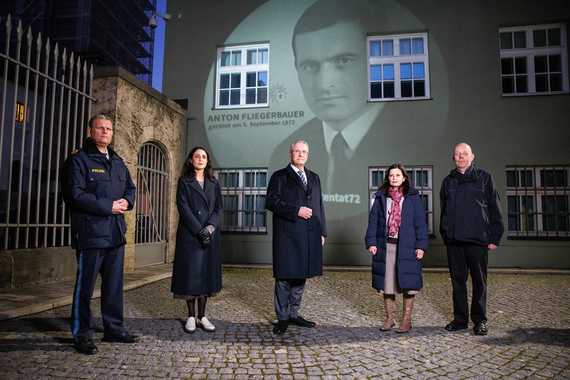Mittwoch, 9. Februar 2022; Vor 50 Jahren starben zw�lf Menschen bei den Olympischen Spielen in M�nchen � darunter auch Polizeiobermeister Anton Fliegerbauer. Mit einer Projektion von Fliegerbauer zusammen mit den Namen der elf weiteren Get�teten auf der Geb�udefassade vor dem Haupteingang des Polizeipr�sidiums M�nchen wird an das Attentat vom 5./6. September 1972 erinnert. �Wir werden seinen heldenhaften Einsatz nie vergessen�, betonte Bayerns Innenminister Joachim Herrmann zum Start der Projektion.