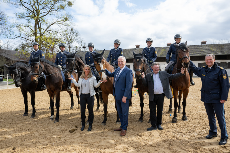 Montag, 3. April 2023; Innenminister Joachim Herrmann hat beim Ortstermin bei der Reiterstaffel auf dem Gelände der Olympia-Reitanlage bekräftigt: Die Olympia-Reitanlage ist Aushängeschild für Bayern und Vorbild für eine nachhaltige Nutzung olympischer Sportstätten. Auf dem Foto: Schirmherrin der berittenen Einheiten Karin Baumüller-Söder, Innenminister Joachim Herrmann, Präsident des Bayerischen Reit- und Fahrverbandes Staatssekretär a.D. Gerhard Eck, Polizeipräsident im Polizeipräsidium München Thomas Hampel 
Copyright: Sebastian Widmann / StMI